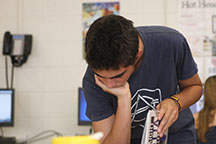 Carlos dilegently searches through the 2015-2016 yearbook.