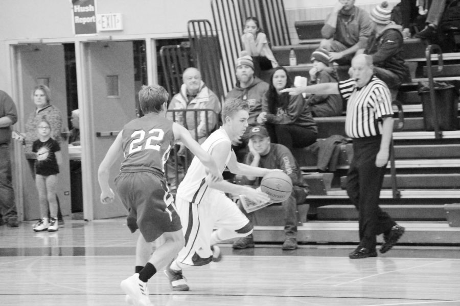 Dodging the Defense: Sophomore, Ryan Holland, goes in for the lay-up, making a clever dodge from the opposing team member. Focusing on his main target of action, he makes a successful shot for his fellow teammates. 