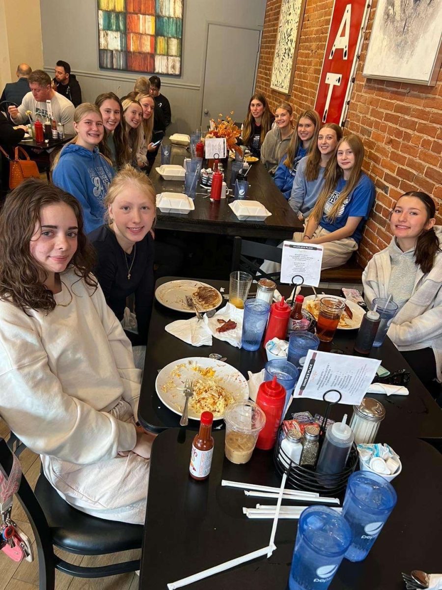 Fueling their bodies, the Galena varsity volleyball players pose for a photo after finishing up their scrumptious breakfast food from Charlies Place. "It was a great way to get together and get some good food before our big game!" Jayme Frank '26 shares. 