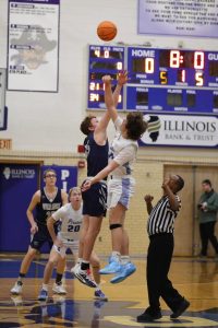 Ready to win! Drew Koenings, pictured taking the jump ball during the basketball game on January 9th against Stockton. Koenings ‘26 said, “I think we came out good and really strong.” Their coach, Matt Wienen, was incredibly proud and happy for his team. Scales Mound Fan Photos Image.