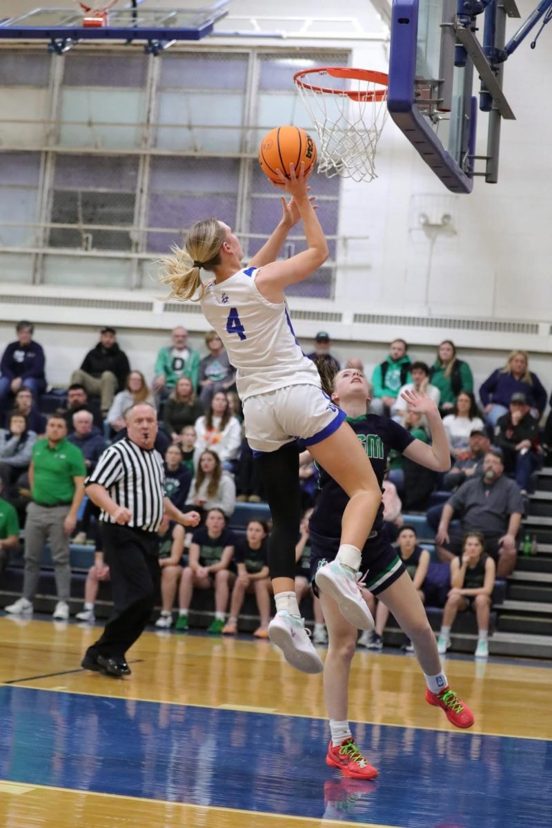 Raising that score! Gracie Furlong ‘25, pictured jumping in order to get the ball in during the basketball game on January 22nd against River Ridge.