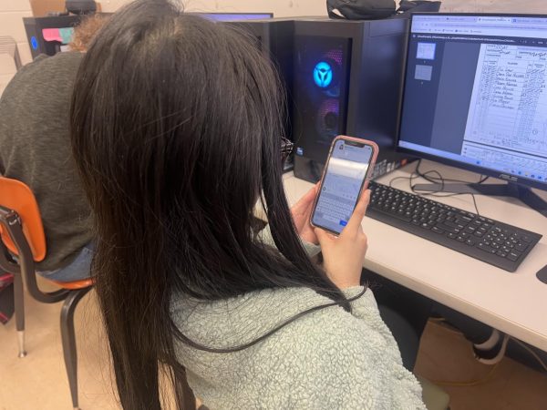 Controversy is rising! Grace McIntyre ‘25, pictured using her Snapchat ai on her phone. McIntyre ‘25 said, “It comes in clutch for publications and helps with captions.” Snapchat has said that over 300 million people use their ai daily. 