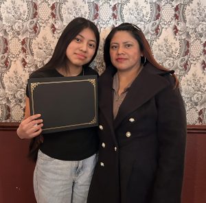 Feeling accomplished,  Sara Perez-Carrillo '27 poses with her mom, Maria Carrillo Cobo, while proudly holding up her award. They were invited to the DeSoto house for a lunch in and to receive the award. "I was very proud of myself when I found out I won and had a great time with my mom at the DeSoto House!" says Perez-Carrillo.