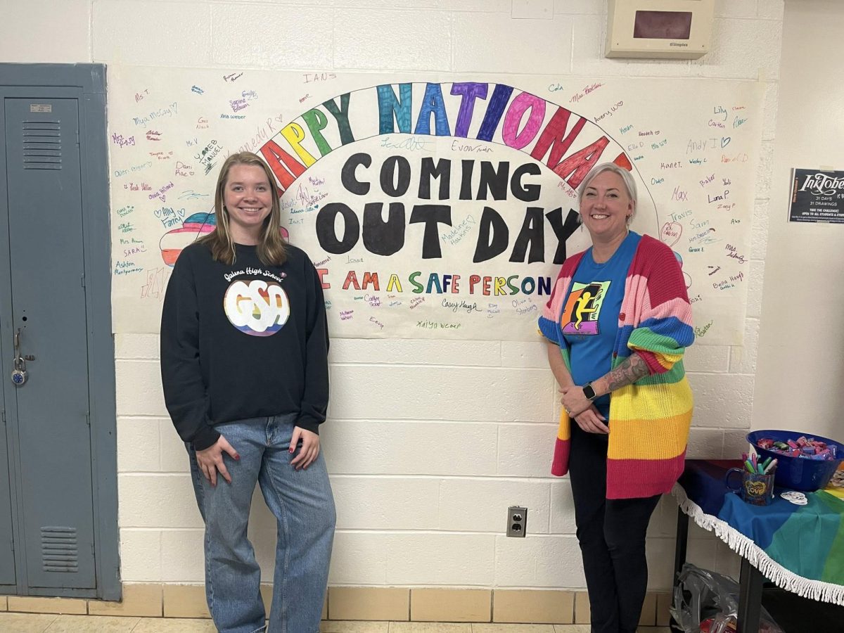 Beaming with pride, GSA club advisers Ms. AB and Mrs. T pose in front of the National Coming Out Day banner. Students can choose to sign the banner to signify that they are a safe person to come out too. "Seeing all the signatures we get and the support from others really means a lot to myself and the rest of GSA," Ms. AB shares. 