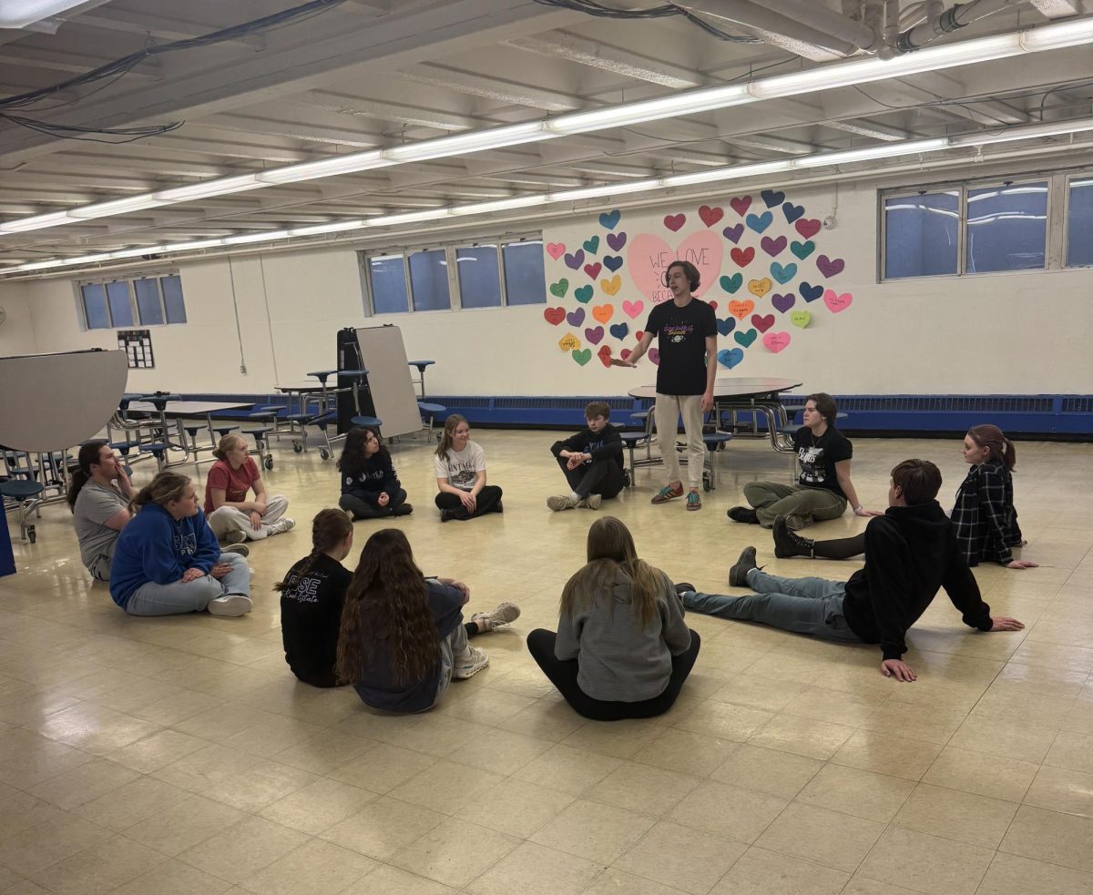 Talents on the stage: Seven Smith ‘28 acts before his act while the Galena High School Drama Club rehearses their new musical, Godspell, in the cafeteria. Smith plays the lead role of Jesus: “I teach disciples in the play the stories of the Bible, and I sing lots of songs!”